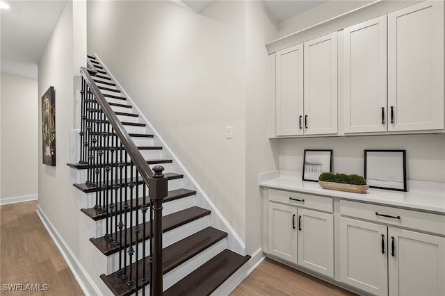 stairway with baseboards and wood finished floors
