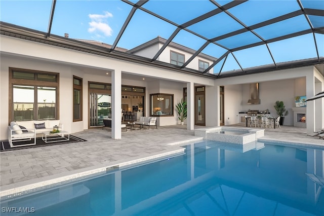 rear view of property featuring outdoor lounge area, stucco siding, glass enclosure, and a patio area