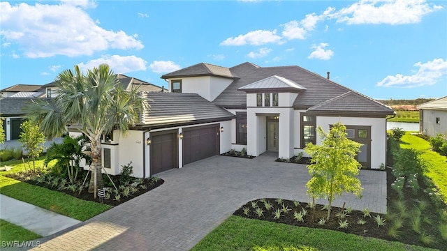 view of front of house featuring stucco siding, decorative driveway, and a garage