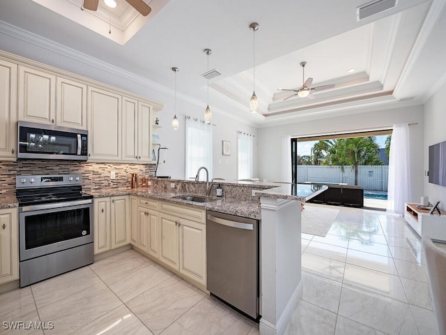 kitchen featuring appliances with stainless steel finishes, kitchen peninsula, sink, and cream cabinetry