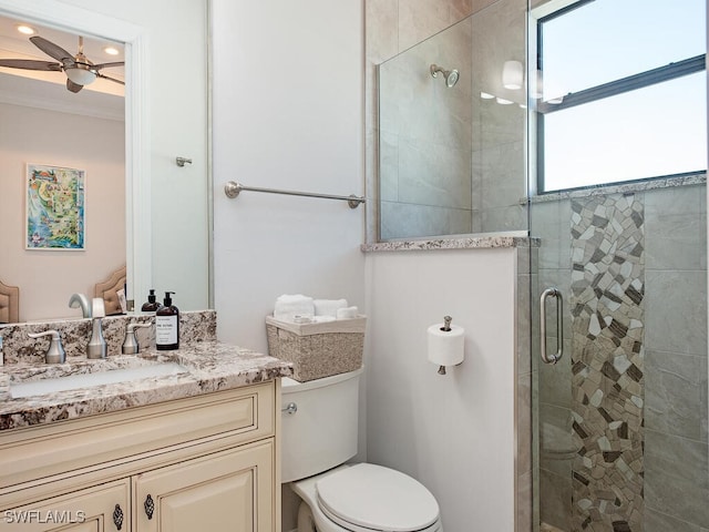 bathroom featuring vanity, toilet, a shower with shower door, and ceiling fan