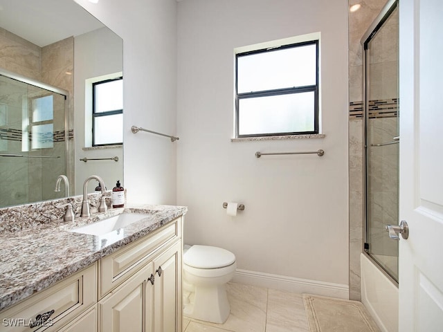 full bathroom featuring toilet, vanity, tile patterned floors, and shower / bath combination with glass door