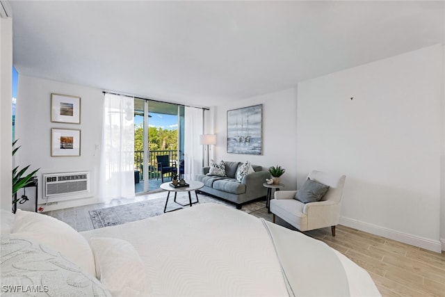 bedroom featuring a wall mounted AC, light wood-type flooring, and access to exterior