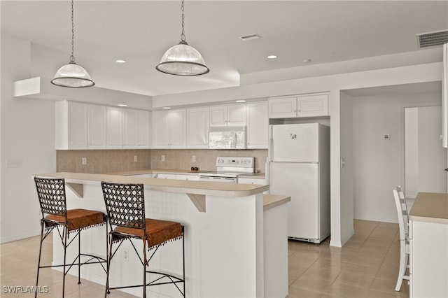 kitchen with decorative backsplash, white cabinetry, pendant lighting, and white appliances