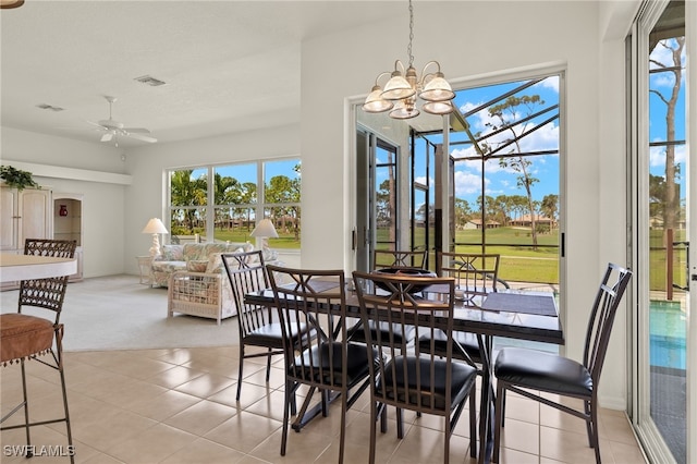 tiled dining area with ceiling fan with notable chandelier