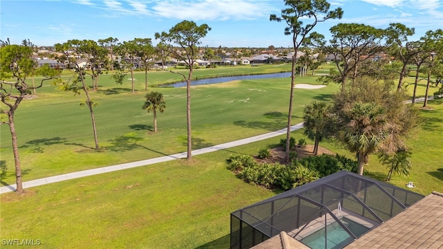 view of community featuring a yard, a water view, view of golf course, and a residential view