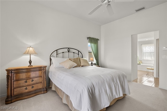 carpeted bedroom with connected bathroom and ceiling fan