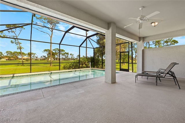 view of swimming pool with a patio, ceiling fan, a lanai, and a yard