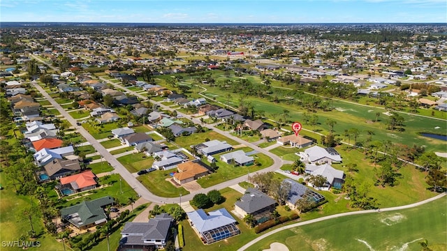drone / aerial view featuring view of golf course and a residential view