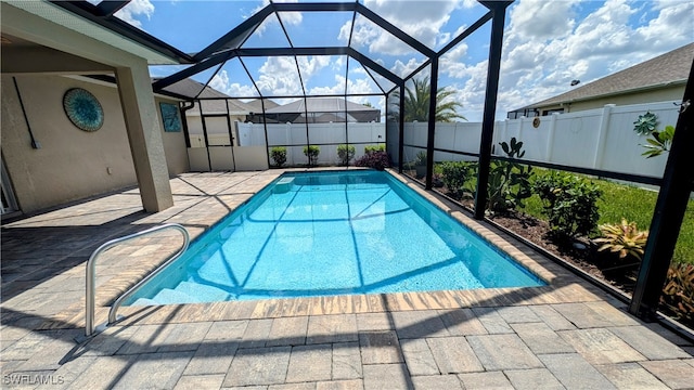 view of pool with glass enclosure and a patio area