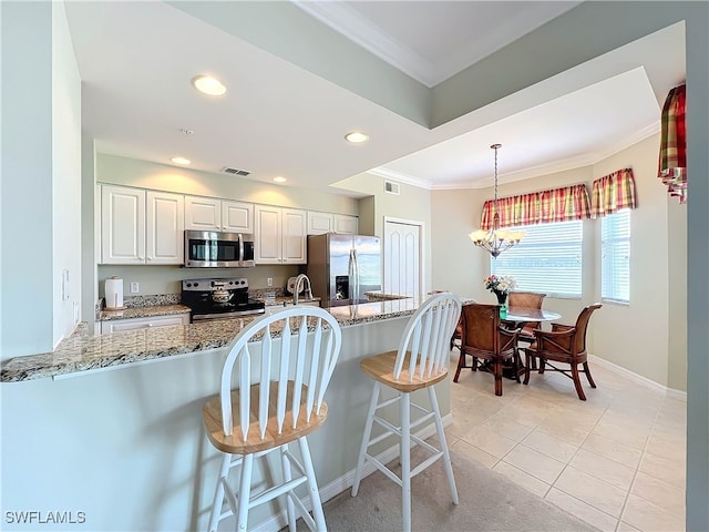 kitchen featuring white cabinetry, kitchen peninsula, light stone countertops, and stainless steel appliances