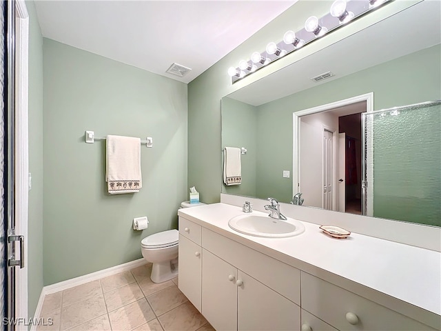 bathroom featuring tile patterned flooring, vanity, toilet, and a shower with door