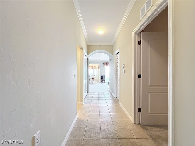 corridor with light tile patterned floors and ornamental molding