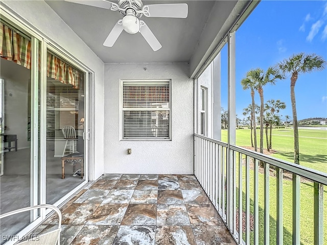 unfurnished sunroom featuring ceiling fan