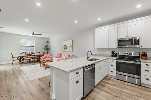 kitchen featuring sink, white cabinetry, stainless steel appliances, and light hardwood / wood-style floors