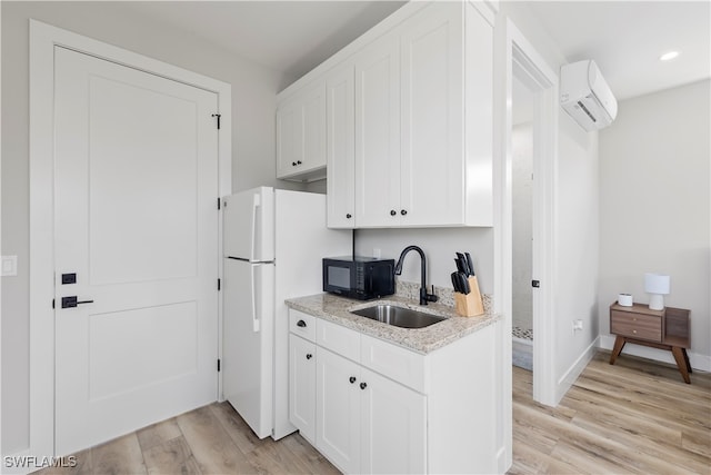 kitchen with light hardwood / wood-style floors, sink, white refrigerator, and a wall unit AC