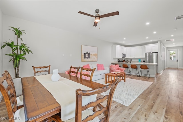 dining space with light hardwood / wood-style floors and ceiling fan