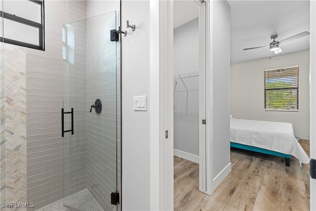 bathroom with walk in shower, wood-type flooring, and ceiling fan