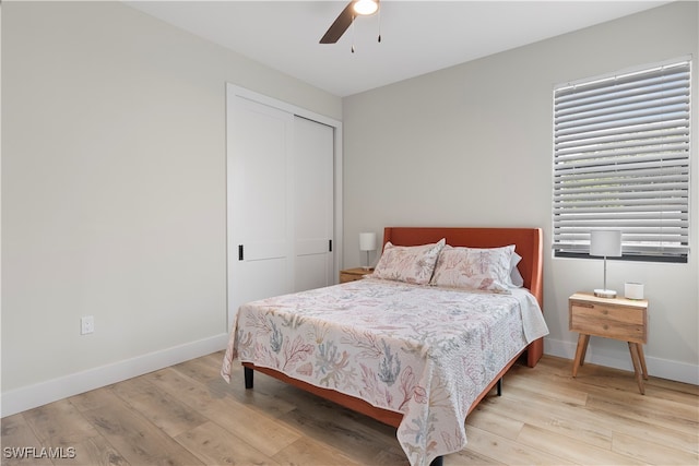 bedroom with light hardwood / wood-style floors, a closet, and ceiling fan