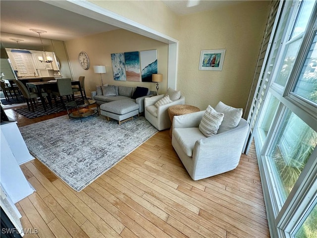 living room featuring light hardwood / wood-style floors, a wealth of natural light, and a chandelier