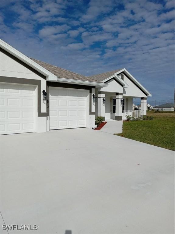 view of front of house featuring a porch, a front lawn, and a garage