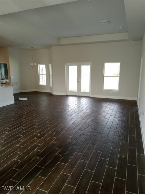 unfurnished room with sink, dark hardwood / wood-style flooring, and a chandelier