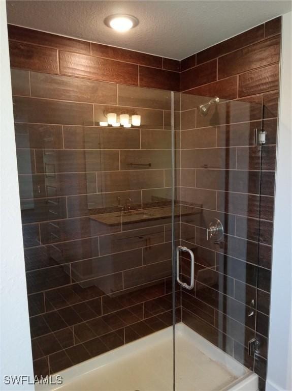 bathroom featuring a textured ceiling and walk in shower