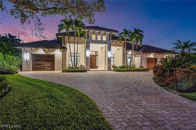 view of front of house featuring a garage and a lawn