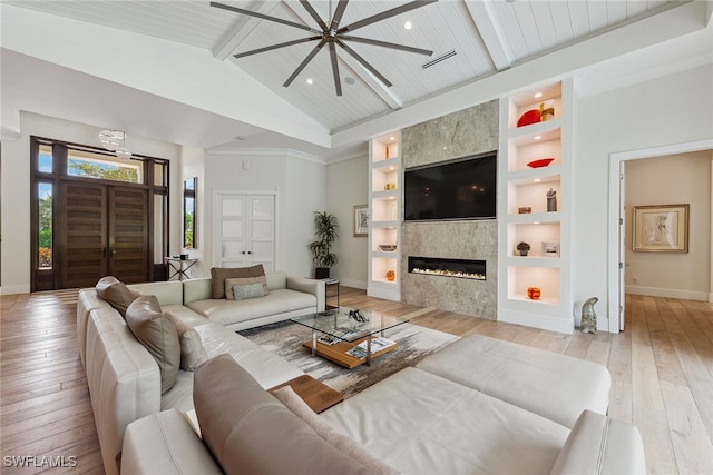 living room with a fireplace, beamed ceiling, wooden ceiling, light hardwood / wood-style flooring, and built in shelves