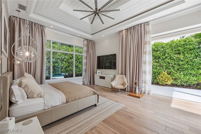 bedroom featuring light hardwood / wood-style floors, a tray ceiling, and ceiling fan