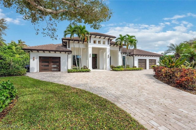 mediterranean / spanish house with a front yard and a garage