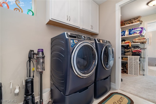 washroom with cabinets, independent washer and dryer, and light colored carpet