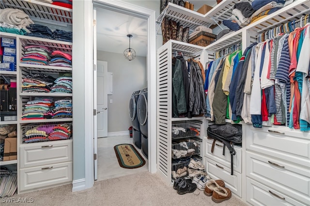 spacious closet with separate washer and dryer and light colored carpet