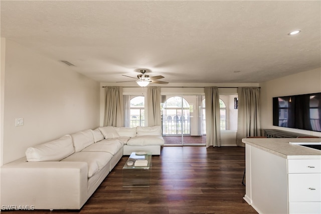 unfurnished living room featuring a textured ceiling, ceiling fan, and dark hardwood / wood-style flooring