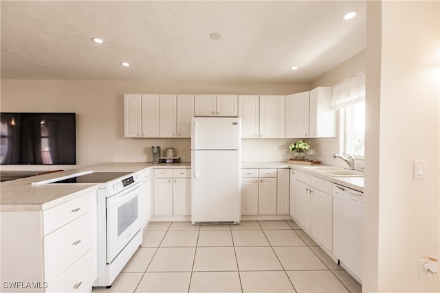 kitchen featuring white appliances, light tile patterned flooring, sink, kitchen peninsula, and white cabinetry