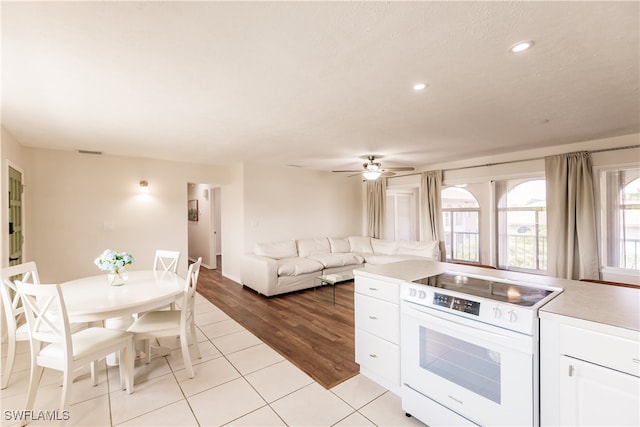 kitchen with white cabinetry, white electric range, light wood-type flooring, and ceiling fan