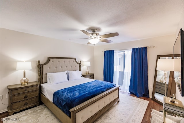 bedroom with ceiling fan, a textured ceiling, and hardwood / wood-style floors