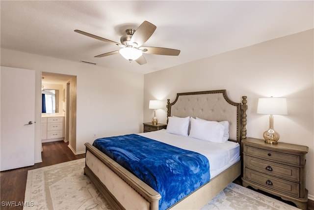 bedroom with ensuite bath, dark wood-type flooring, and ceiling fan