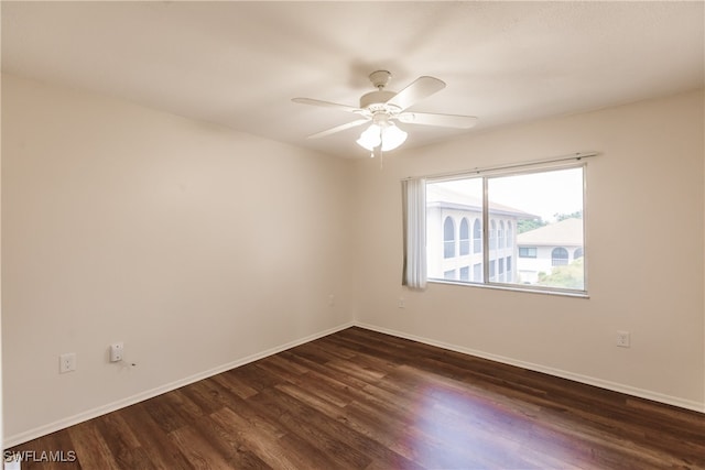 spare room featuring dark wood-type flooring and ceiling fan