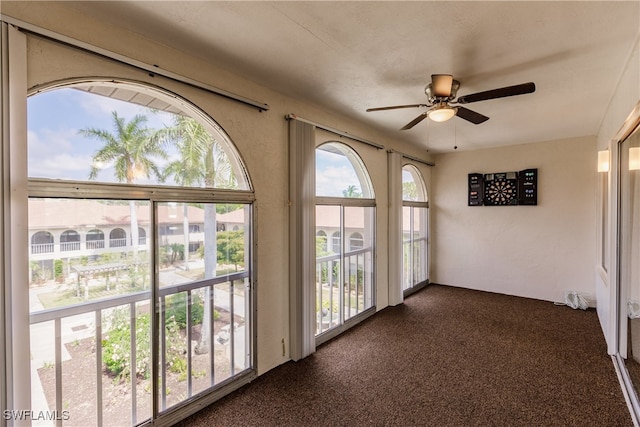 unfurnished sunroom with ceiling fan