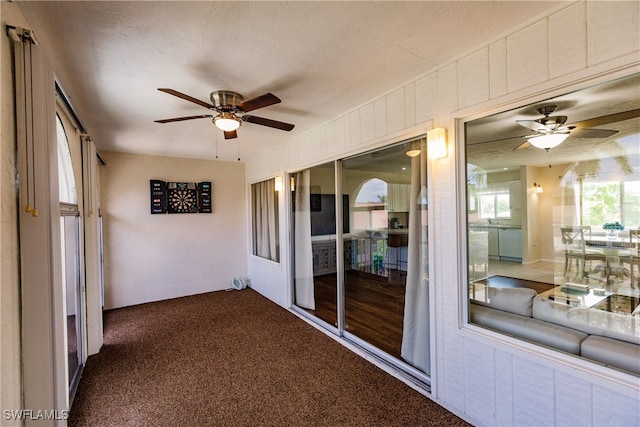 unfurnished sunroom with ceiling fan