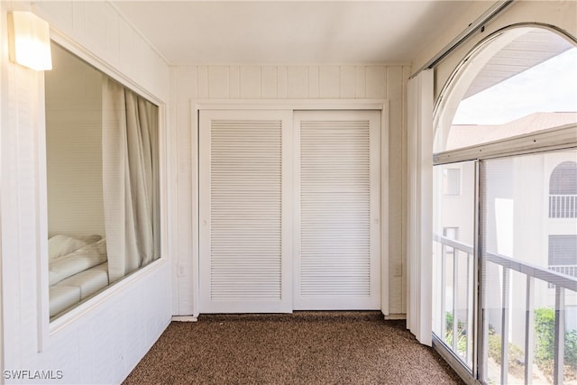 hall with dark colored carpet