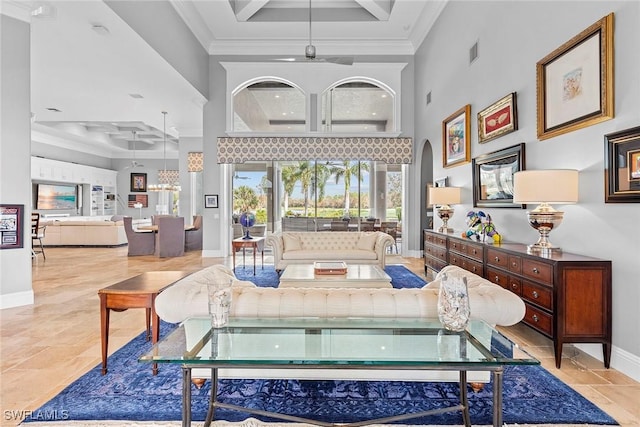 living room with ornamental molding, a raised ceiling, and a high ceiling