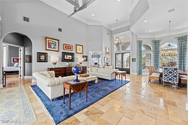 living room featuring ornamental molding, a high ceiling, and a notable chandelier