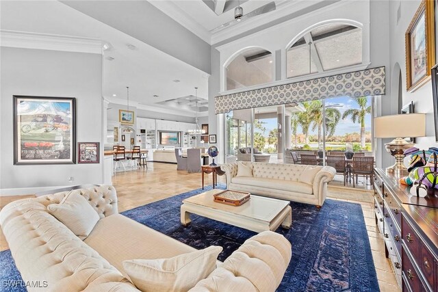 living room featuring a high ceiling, ceiling fan, and ornamental molding