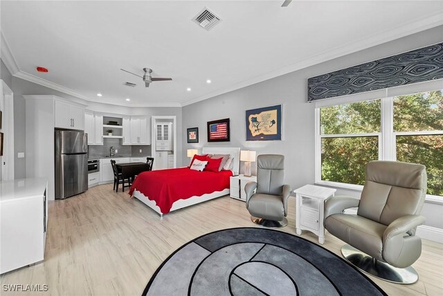 bedroom featuring ceiling fan, sink, light hardwood / wood-style flooring, stainless steel fridge, and crown molding