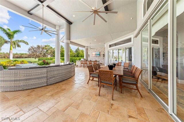 sunroom / solarium with a healthy amount of sunlight, beamed ceiling, and a chandelier