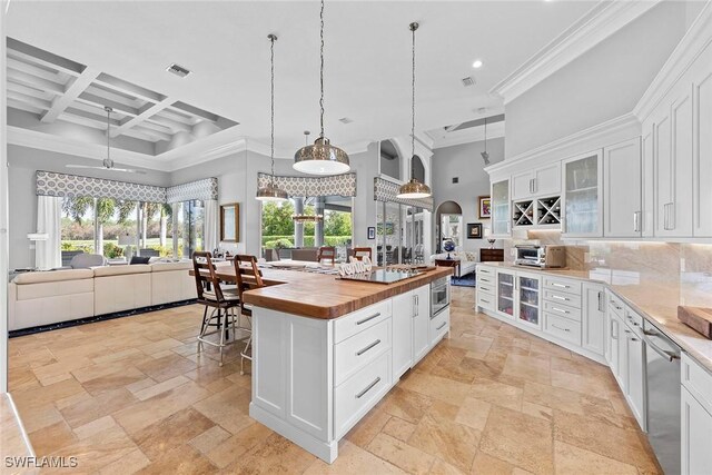 kitchen with wood counters, a kitchen island, white cabinetry, and coffered ceiling