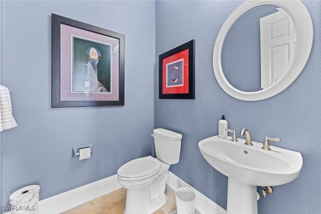 bathroom with tile patterned flooring, toilet, and sink