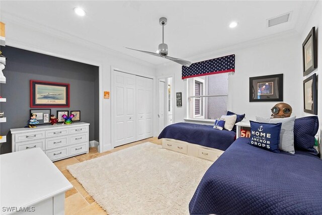 tiled bedroom with ceiling fan, crown molding, and a closet